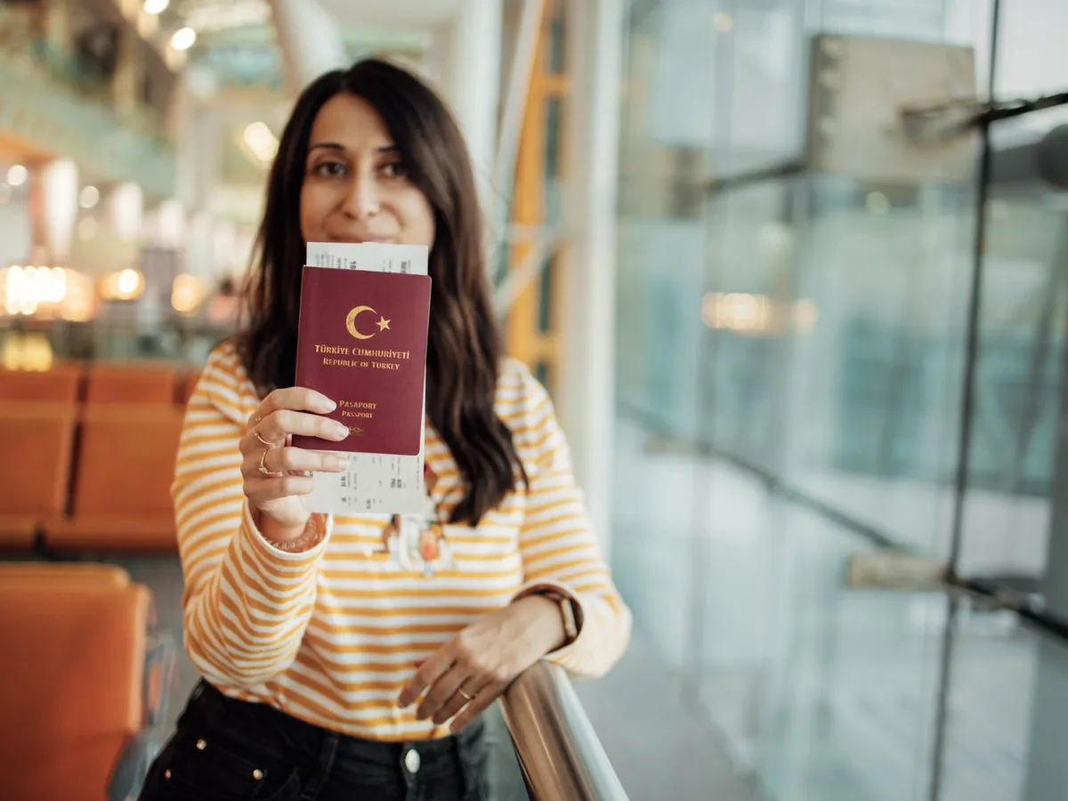 Ergotherapeutin mit Reisepass am Flughafen vor der Abreise nach Deutschland