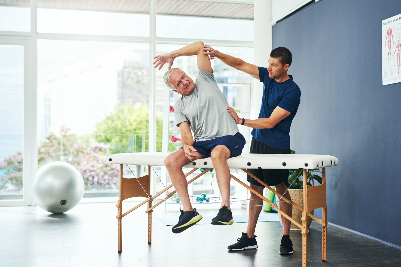 Therapeut übt mit Patient eine Bewegung